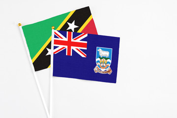 Falkland Islands and Saint Kitts And Nevis stick flags on white background. High quality fabric, miniature national flag. Peaceful global concept.White floor for copy space.