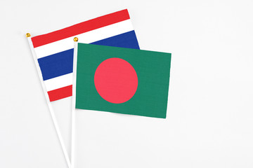 Wall Mural - Bangladesh and Thailand stick flags on white background. High quality fabric, miniature national flag. Peaceful global concept.White floor for copy space.