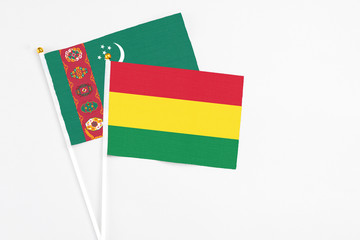 Bolivia and Turkmenistan stick flags on white background. High quality fabric, miniature national flag. Peaceful global concept.White floor for copy space.