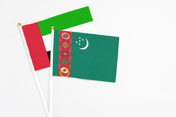 Turkmenistan and United Arab Emirates stick flags on white background. High quality fabric, miniature national flag. Peaceful global concept.White floor for copy space.
