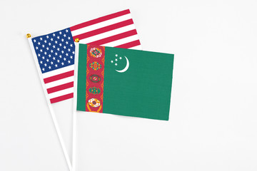Turkmenistan and United States stick flags on white background. High quality fabric, miniature national flag. Peaceful global concept.White floor for copy space.