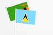 © sezerozger - Saint Lucia and Zambia stick flags on white background. High quality fabric, miniature national flag. Peaceful global concept.White floor for copy space.