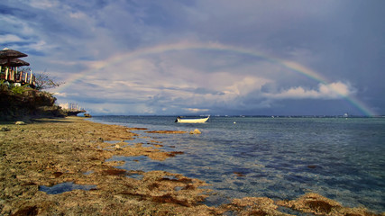 boat on the sea and rainbow in the sky