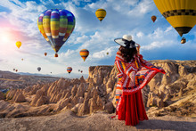 Beautiful Girl Standing And Looking To Hot Air Balloons In Cappadocia, Turkey.