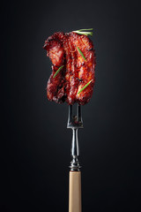 Wall Mural - Grilled pork belly with rosemary on a fork.