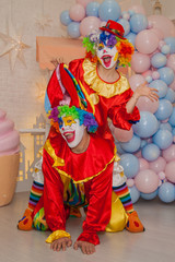 Wall Mural - Funny clowns from the circus. Clown boy and clown girl show emotions