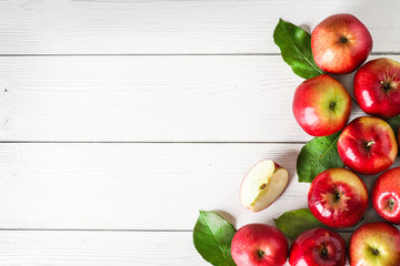 Wall Mural - Fresh red apples on white background top view. Green apple leaves and fruits copy space.