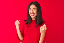 Young Beautiful Chinese Woman Wearing Casual Dress Standing Oer Isolated Red Background Very Happy And Excited Doing Winner Gesture With Arms Raised, Smiling And Screaming For Success. Celebration