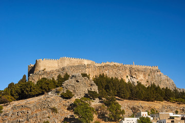 Wall Mural - White houses of a greek town and a medieval fortress in Lindos .