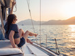 © Alexander - attractive young woman in a striped t-shirt enjoys the sunset on the deck of a sailing yacht. Sailing regatta