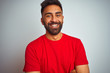 © Krakenimages.com - Young indian man wearing red t-shirt over isolated white background happy face smiling with crossed arms looking at the camera. Positive person.