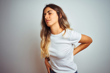 Canvas Print - Young beautiful woman wearing casual white t-shirt over isolated background Suffering of backache, touching back with hand, muscular pain