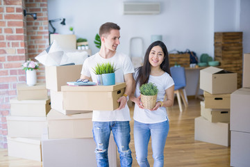 Young beautiful couple moving cardboard boxes at new home