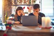 Young beautiful couple sitting using laptop around christmas decoration at home tired rubbing nose and eyes feeling fatigue and headache. Stress and frustration concept.