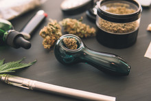 Cannabis Legalisation. Marijuana Smoking Pipe Macro Cannabis Buds Weed On Black Wood Background. CBD And THC On Buds In Cannabis.
