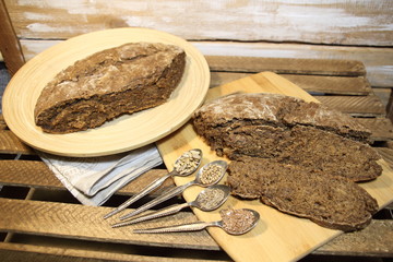 Canvas Print - Home made brown bread with seeds on wooden background