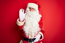 Middle Age Handsome Man Wearing Santa Costume Standing Over Isolated Red Background Waiving Saying Hello Happy And Smiling, Friendly Welcome Gesture