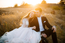 Beautoful Couple, Sitting An Huuging In A Fied, On Marriege Day, Relaxing On Sunset