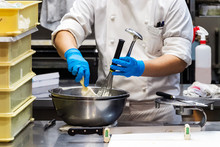 A Male Pastry Chef Using A Spatula And A Whisk While Making Whipped Cream.