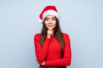 Wall Mural - Girl with christmas hat over isolated blue background laughing