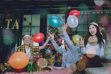 Group of friends to enjoy Christmas party filled with gift boxes a variety of colors and food. They celebrated until the morning in the living room.