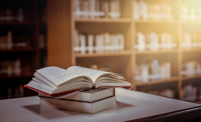 Poster - stack of books in the library and blur bookshelf background