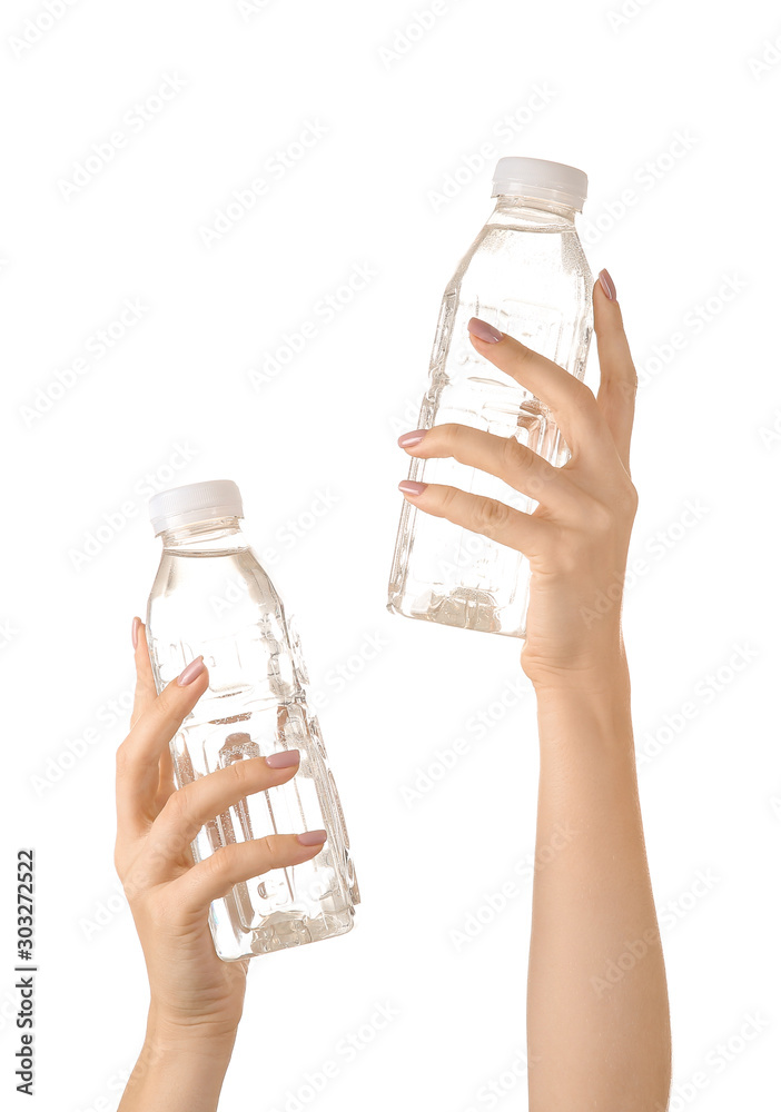 Female hands with bottles of water on white background