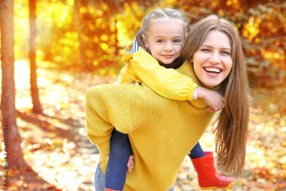 Happy mother and daughter in autumn park