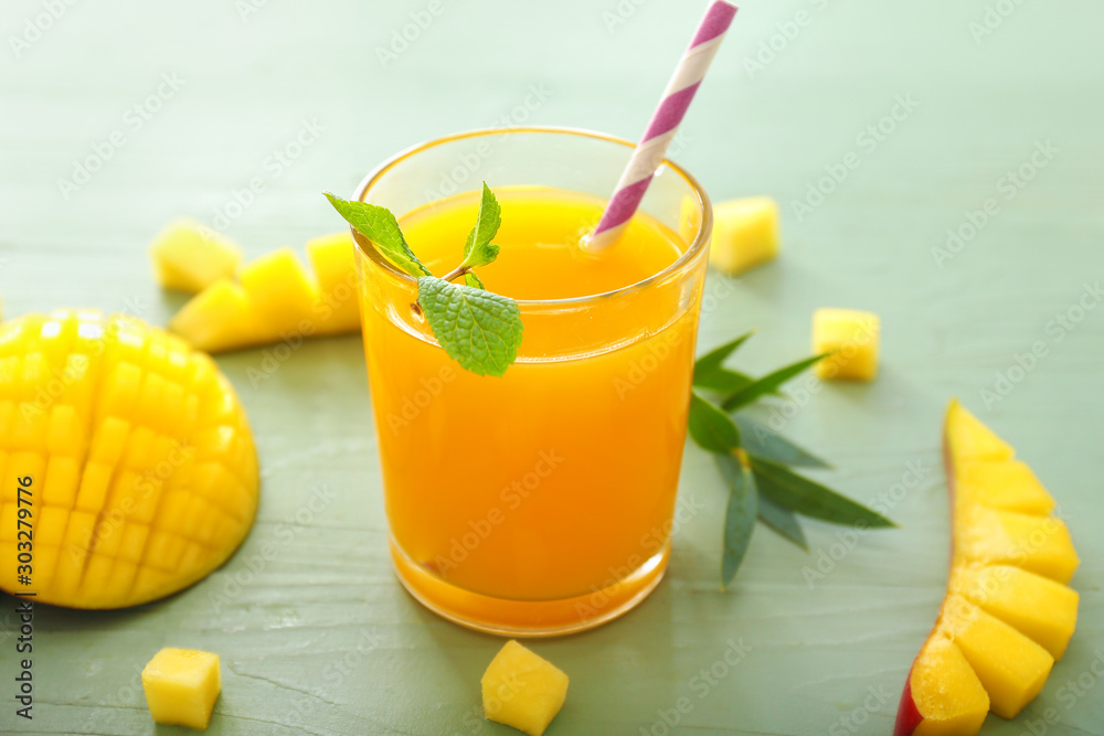 Glass of tasty mango juice on table