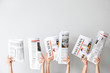 © Pixel-Shot - Female hands with newspapers on light background