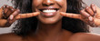 Leinwandbild Motiv Unrecognizable black woman pointing at her healthy white teeth, closeup