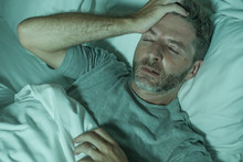 Dramatic Portrait Of Stressed And Frustrated Man In Bed Awake At Night Suffering Insomnia Sleeping Disorder Tired And Desperate Unable Sleep Feeling Exhausted