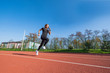 © serejkakovalev - Young female runner training in summer day outdoors on the studium