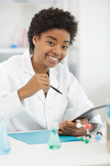 young woman doctor writing in book