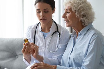 Wall Mural - Young female doctor prescribe medicine bottle to old grandma patient