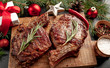 © александр таланцев - Christmas dinner for two, grilled beef steak ribeye, herbs and spices on a stone table with a Christmas tree and New Year's toys