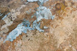 Wand in sandsteinfarben mit Resten aus weißem Putz schmutzig, alt, zerfallen Hintergrund