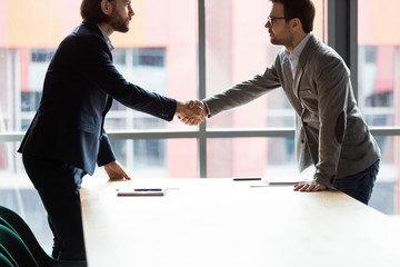 Poster - Confident serious two businessmen shaking hands at office.