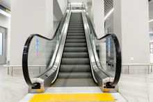 modern people-free escalator with tiles for the blind at the airport