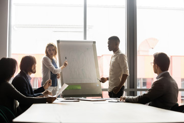 Wall Mural - Focused young multiracial presenters explaining market research to colleagues.