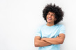 smiling young man with afro hair and arms crossed smiling by white background