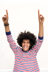 Wall Mural - smiling young arab man with afro hair and arms raised pointing fingers up