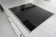 Built-in induction cooker with a black glass surface in the kitchen