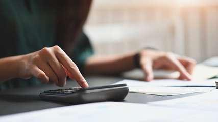 Closeup woman hands calculate financial on table.