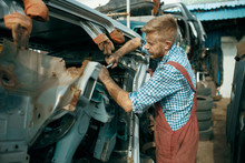 Male Repairman Poses On Car Junkyard