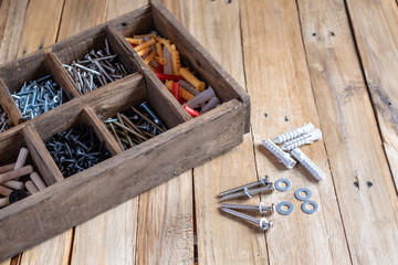 Different types and sizes of screw in wooden organizer box, work tools.