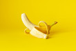 canvas print picture - peeled banana on yellow background
