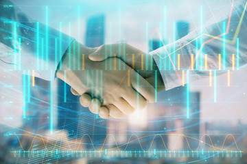 Double exposure of financial graph on cityscape background with two businessman handshake. Concept of stock market deal