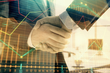 Multi exposure of financial graph on office background with two businessmen handshake. Concept of success in business