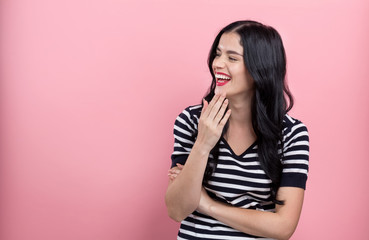Wall Mural - Happy young woman on a pink background